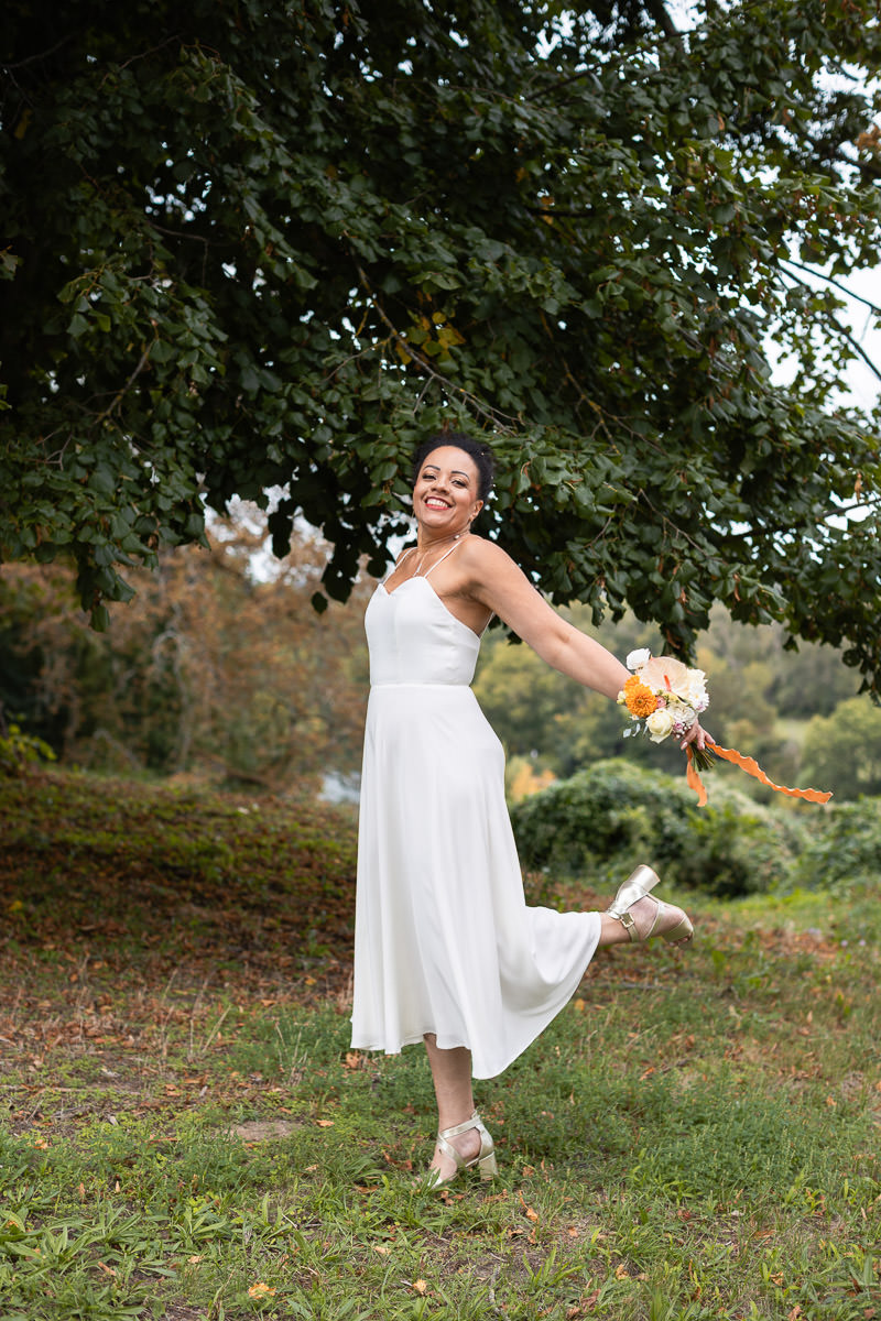 mariée avec robe en satin Bridgerton et son bouquet de fleurs